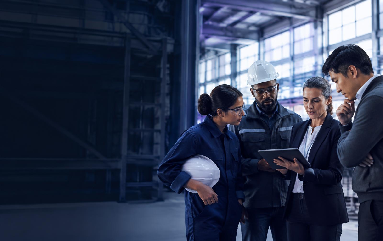Workforce team reviewing data on a tablet in an industrial facility